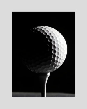 Affiche en noir et blanc d’une balle de golf éclairée fortement sur fond noir, style artistique et minimaliste