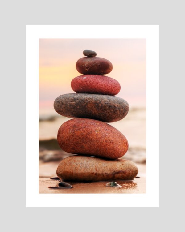 Affiche de galets empilés sur sable humide au coucher du soleil, ambiance zen et naturelle